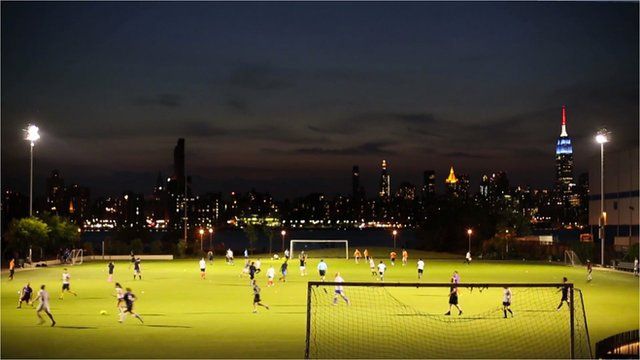 A football field in Brooklyn with Manhattan skyline behind