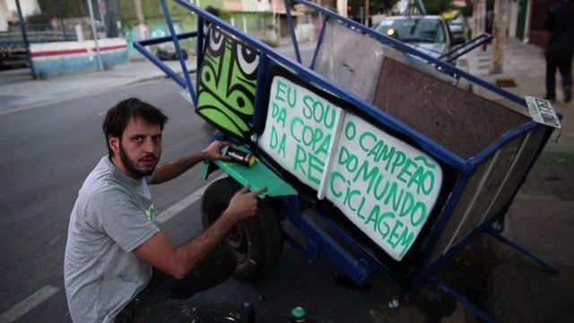 Thiago Mundano painting a trash cart