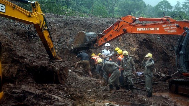 rescue workers dig in the mud