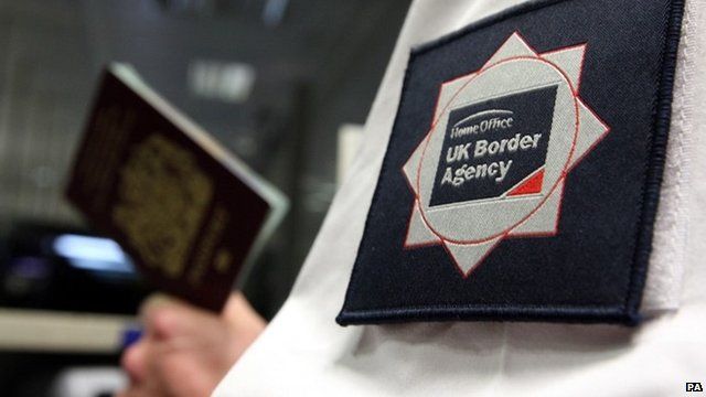 UK Border Agency officer holding a passport