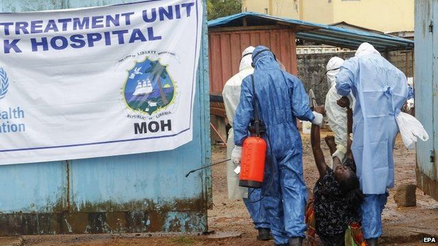 Health workers in Liberia take a suspected patient into a treatment centre
