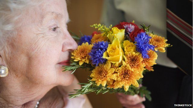 person smelling flowers