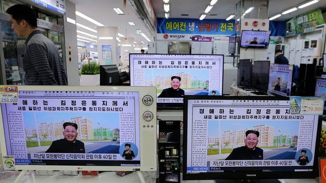 A man walks past an electronic shop in Seoul, South Korea, where TV monitors are displaying a news programme showing a North Korean newspaper with a photo of North Korean leader Kim Jong Un, 14 October 2014