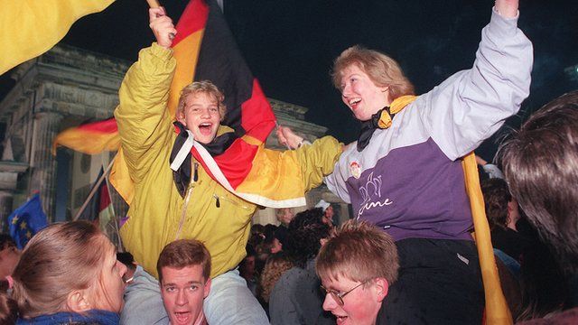 Berliner youths wave German flags during the celebration of the country's reunification at the Brandenburg Gate in Berlin 03 October 1990