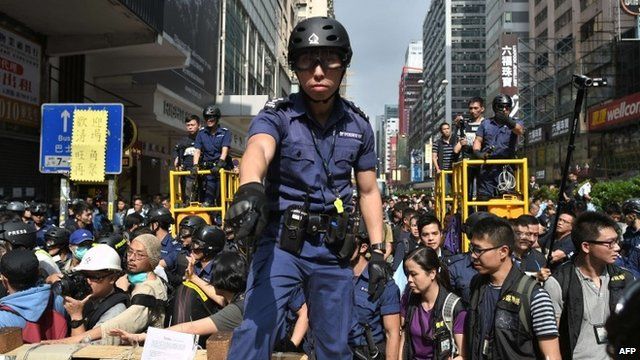 Police officer standing on barricade in Mong Kok district