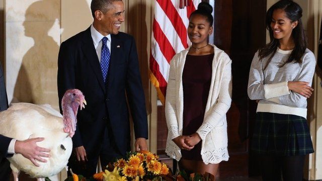 President Barack Obama smiles at his his daughters Sasha and Malia after he pardoned "Cheese" and his alternate Mac (not shown)