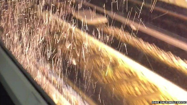 Sparks from fire under train viewed from inside train carriage