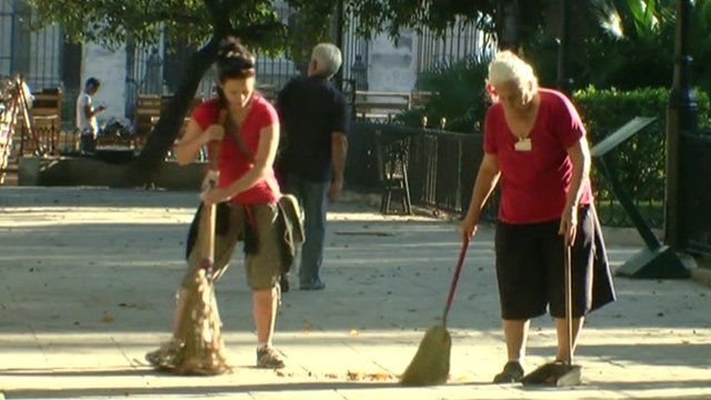 women sweeping the street