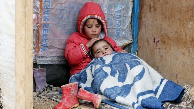 A Syrian refugee girl sits with her brother at a makeshift settlement in Bar Elias in the Bekaa valley January 5, 2015