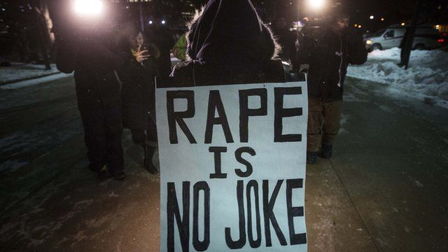 Protester wearing a sign reading 'Rape is no joke'