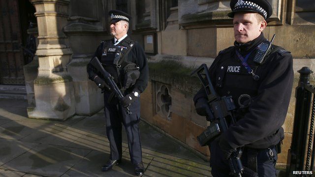 Armed police officers stand on duty outside the Houses of Parliament in Westminster, central London November 24, 2014