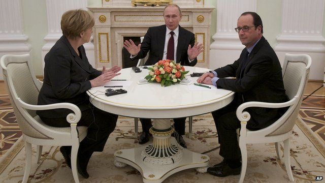 Russian President Vladimir Putin (c) gestures during talks with German Chancellor Angela Merkel (l) and French President Francois Hollande (r) on 6 February 2015