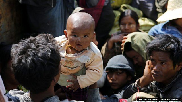 A man takes care of his baby onboard rescue truck fleeing from Kokang capital Laukkai, on 17 February 2015