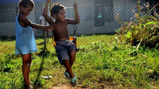 Children play on a swing in Vanuatu