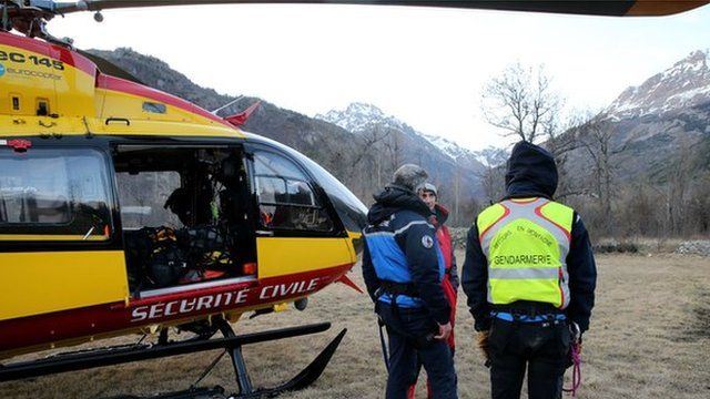 French gendarmes and rescuers stand near a helicopter on April 1, 2015 in Vallouise, in the French Alps