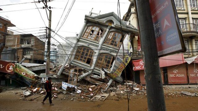 Man walks along the street near a collapsed house following Saturday"s earthquake in Kathmandu, Nepal