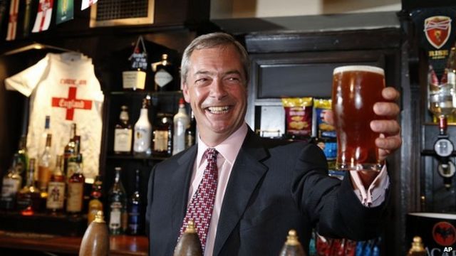 Nigel Farage raises a pint of ale in a pub