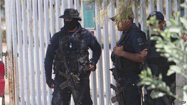 Mexican state police stand guard near the entrance of Rancho del Sol, near Vista Hermosa