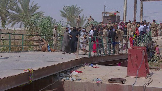 Residents of Ramadi waiting at a river crossing to Baghdad