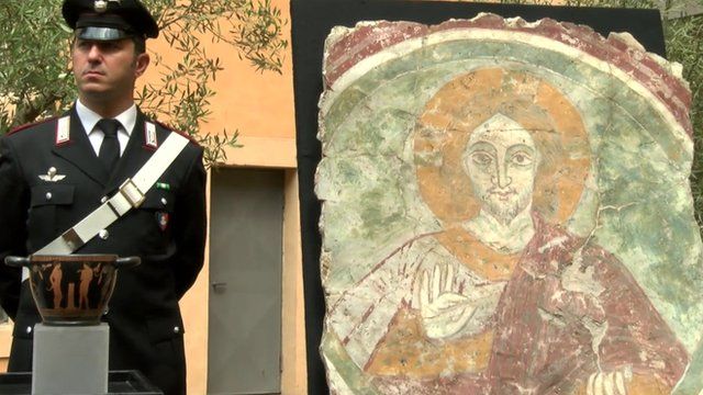 Italian police officer standing next to recovered fresco