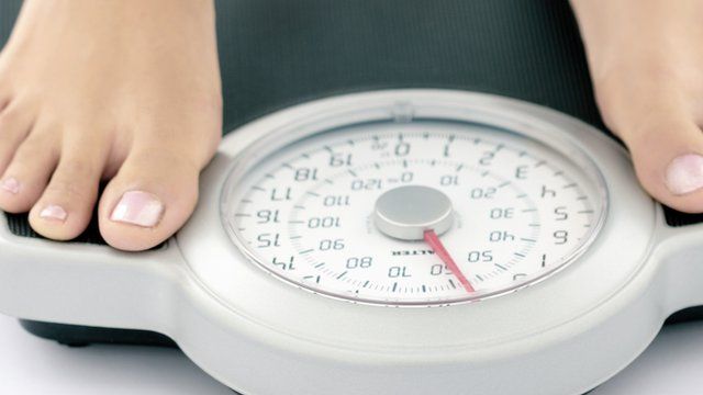 Close up of woman's feet on weighing scales