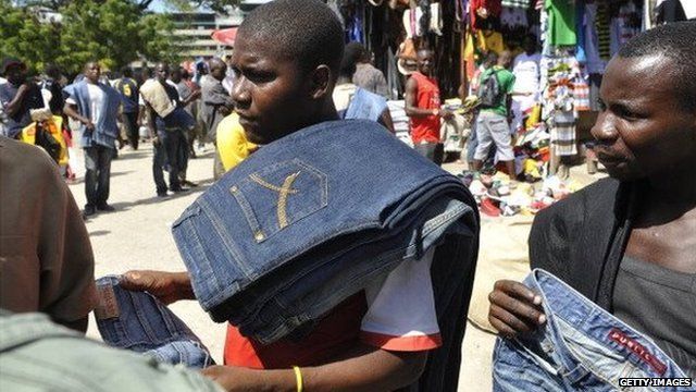 Tanzanian Juma Dihule 21-years old (C) sells second hand jeans at the Kariokor market in Dar es Salaam on May 14, 2011.