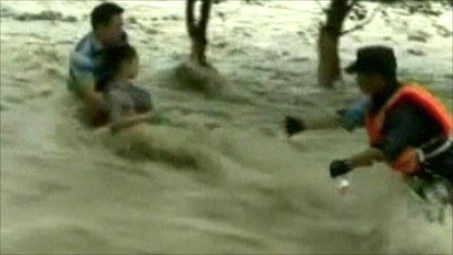 Woman is rescued from torrential water