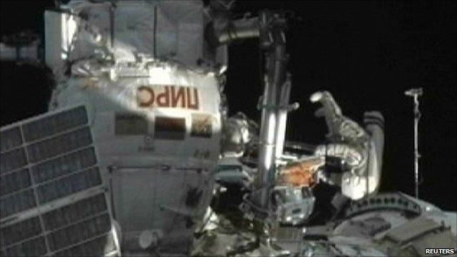 Russian cosmonaut Oleg Skripochka (upside down) emerging from ISS