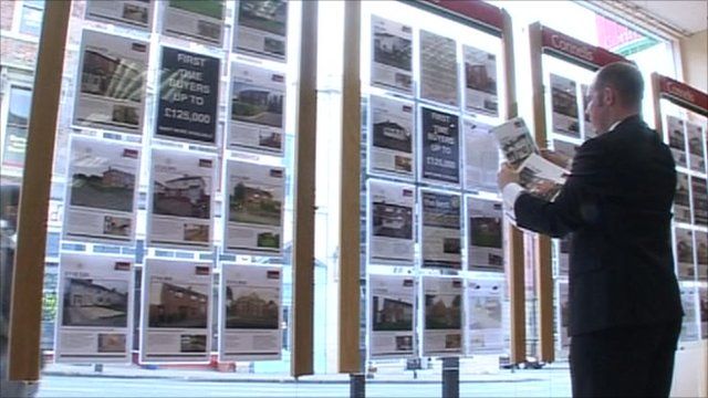 Estate agent with advert for houses
