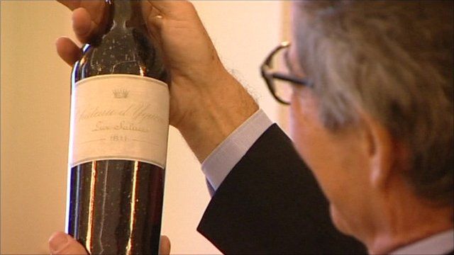 Collector holds up bottle of win bought for £75,000