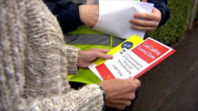 Woman holding a 'cold calling control zone' leaflet