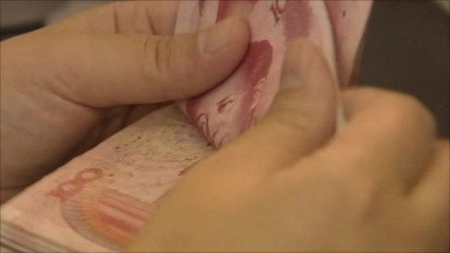 A man counting Chinese banknotes