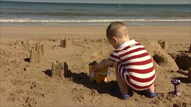 Little boy building sand castles on beach