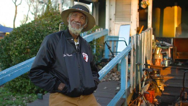 Bluesman Dr Burt stands in front of porch