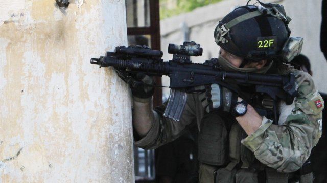 A NATO soldier aims his weapon during a gun battle in Kabul, Afghanistan