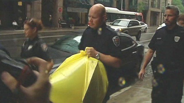 Police carry a yellow bag