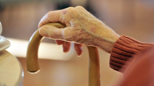 Elderly person with walking stick