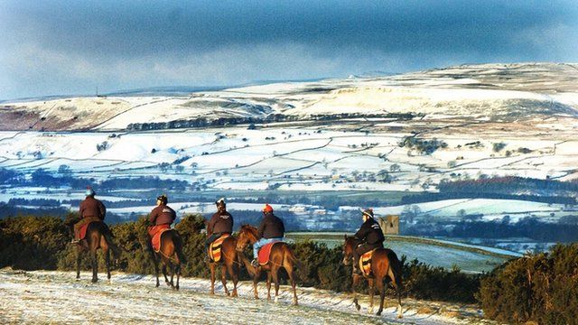 Snow covered landscape with jockeys training