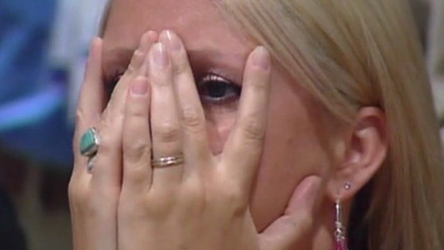Woman holds head in hands