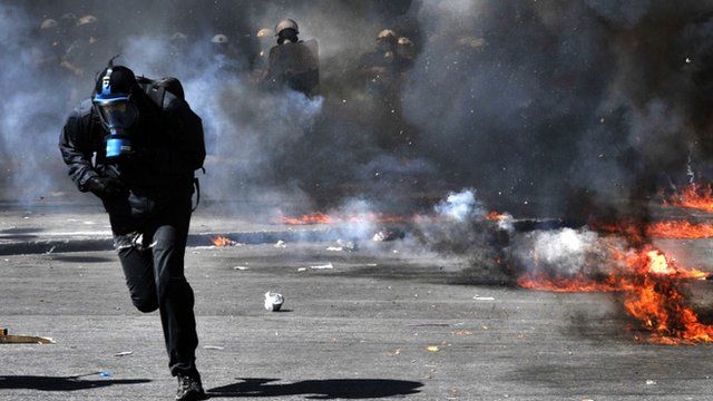 Protestor runs from riot police