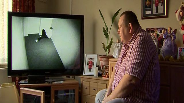 Andrew Parry yn gwylio DVD o'i fab mewn ystafell 'seibiant'