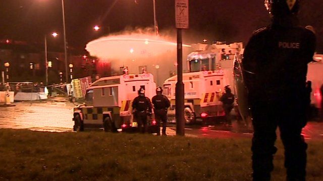 Riot police firing water cannon