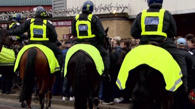 Police officers on horses outside a football match