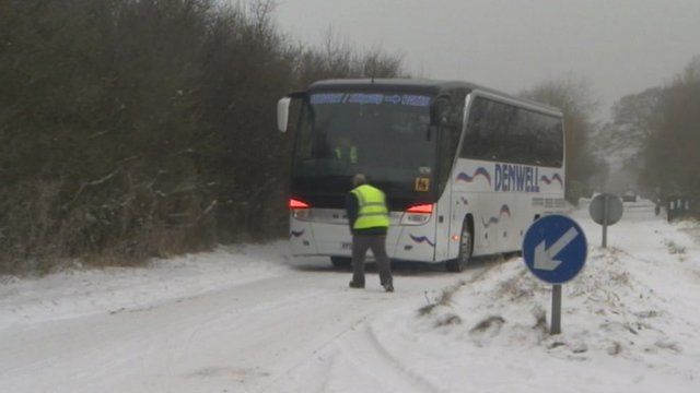 A coach battles a snow-covered road in the Cotswolds