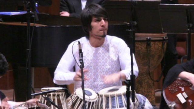 Member of orchestra playing drums