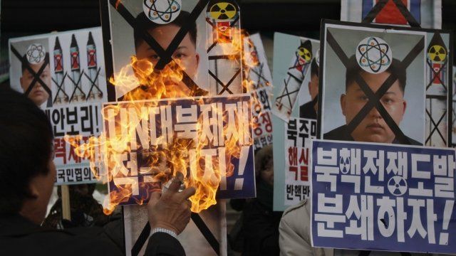 An activist from an anti-North Korea civic group burns a portrait of North's leader Kim Jong-un during a rally against North Korea's nuclear test near the U.S. embassy in central Seoul.