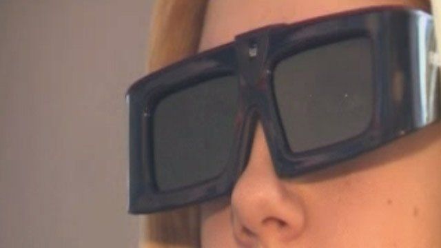 Merch yn gwisgo sbectol 3-D