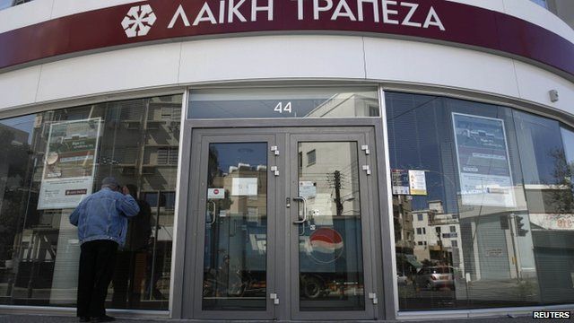Man peers into closed Cypriot bank