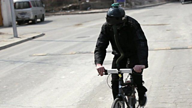Matt Hope wearing fighter pilot helmet while riding the "breathing bike"