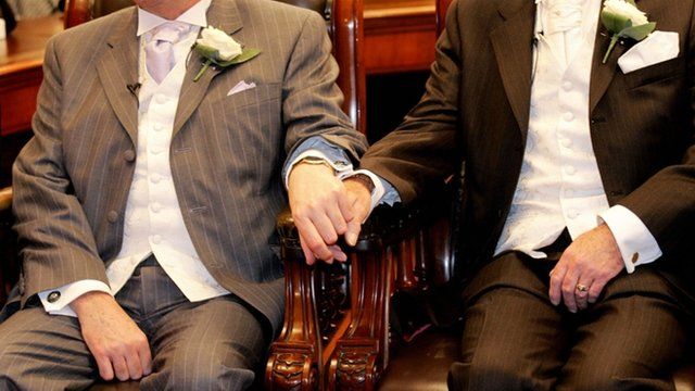 A gay couple hold hands